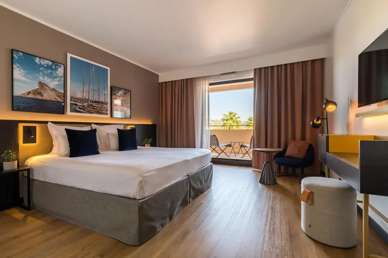 Une chambre lumineuse avec un grand lit et un balcon.