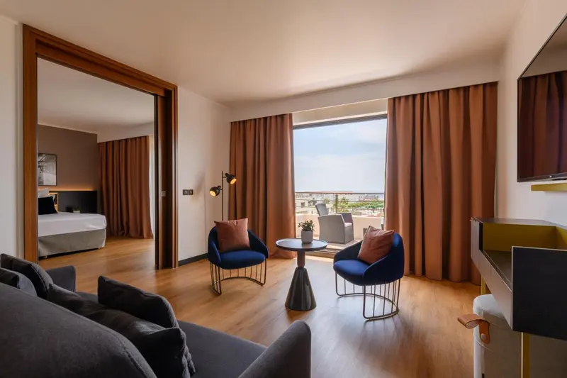 Espace de vie intérieur avec canapés, fauteuils et vue sur l'extérieur.