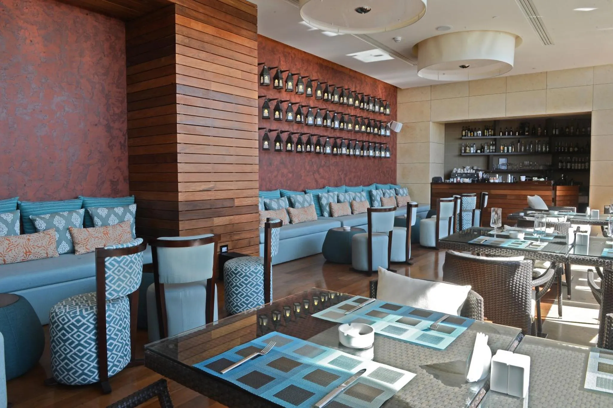 Une salle lumineuse avec des tables dressées et des banquettes confortables.