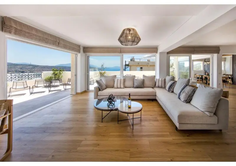 Un salon spacieux s'ouvre sur une terrasse avec vue sur la mer.