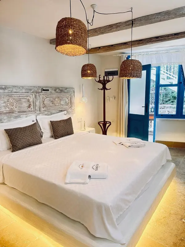Une chambre lumineuse avec un grand lit recouvert de linge blanc.