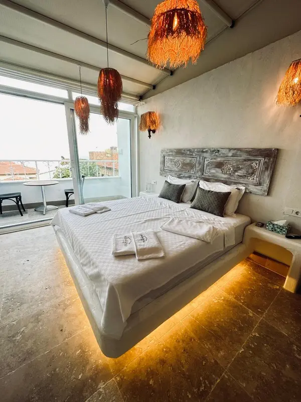 Une chambre lumineuse avec un grand lit et une décoration murale originale.