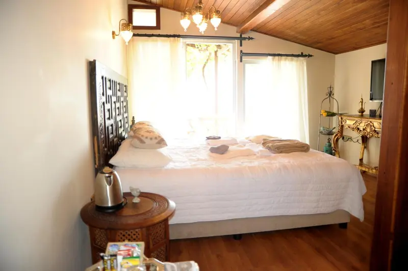 Une chambre lumineuse avec un grand lit recouvert de coussins et de couvertures.
