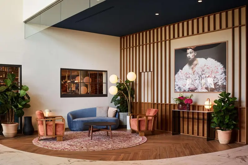 Un espace de détente avec canapés et fauteuils près d'une œuvre d'art murale.