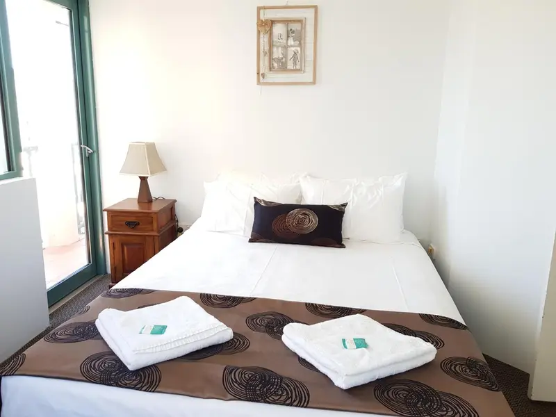 Une chambre lumineuse avec un grand lit et une décoration sobre.