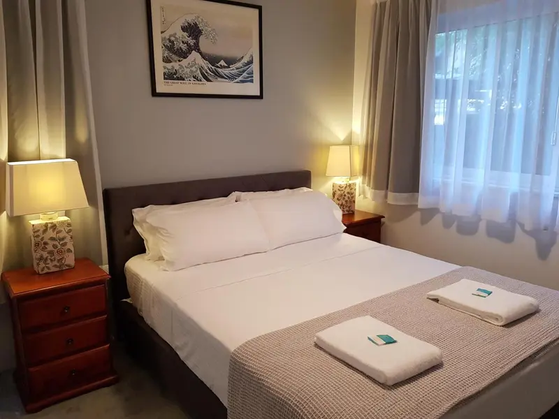 Une chambre lumineuse avec un grand lit et des tables de chevet.