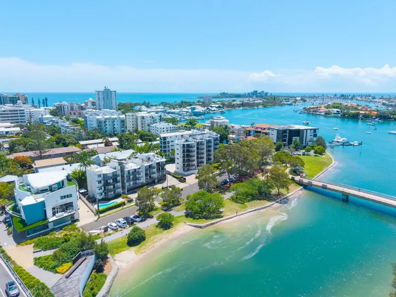 Vue aérienne d'un complexe hôtelier au bord de l'eau avec une plage et une marina.