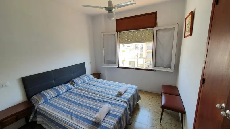 Une chambre lumineuse avec un lit double et une fenêtre.
