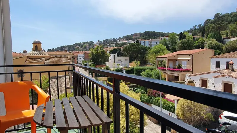 Vue d'une terrasse avec mobilier donnant sur un paysage urbain et verdoyant.