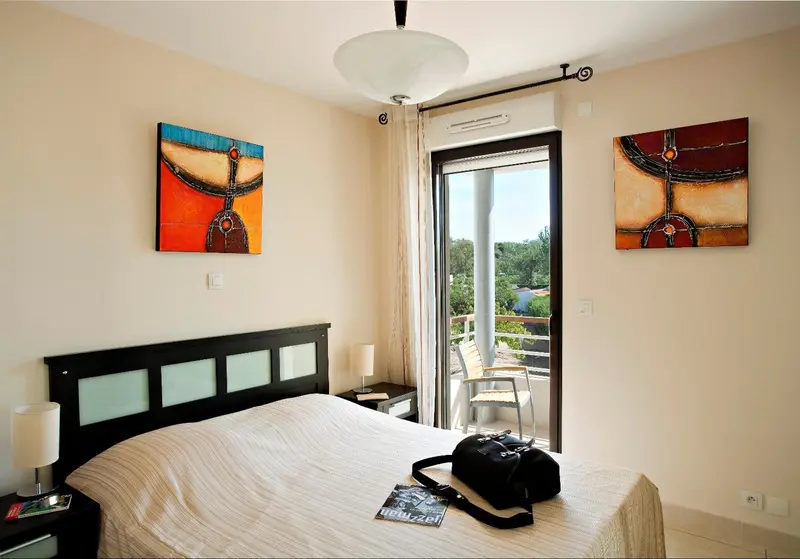 Une chambre lumineuse avec un grand lit et un accès à une terrasse.