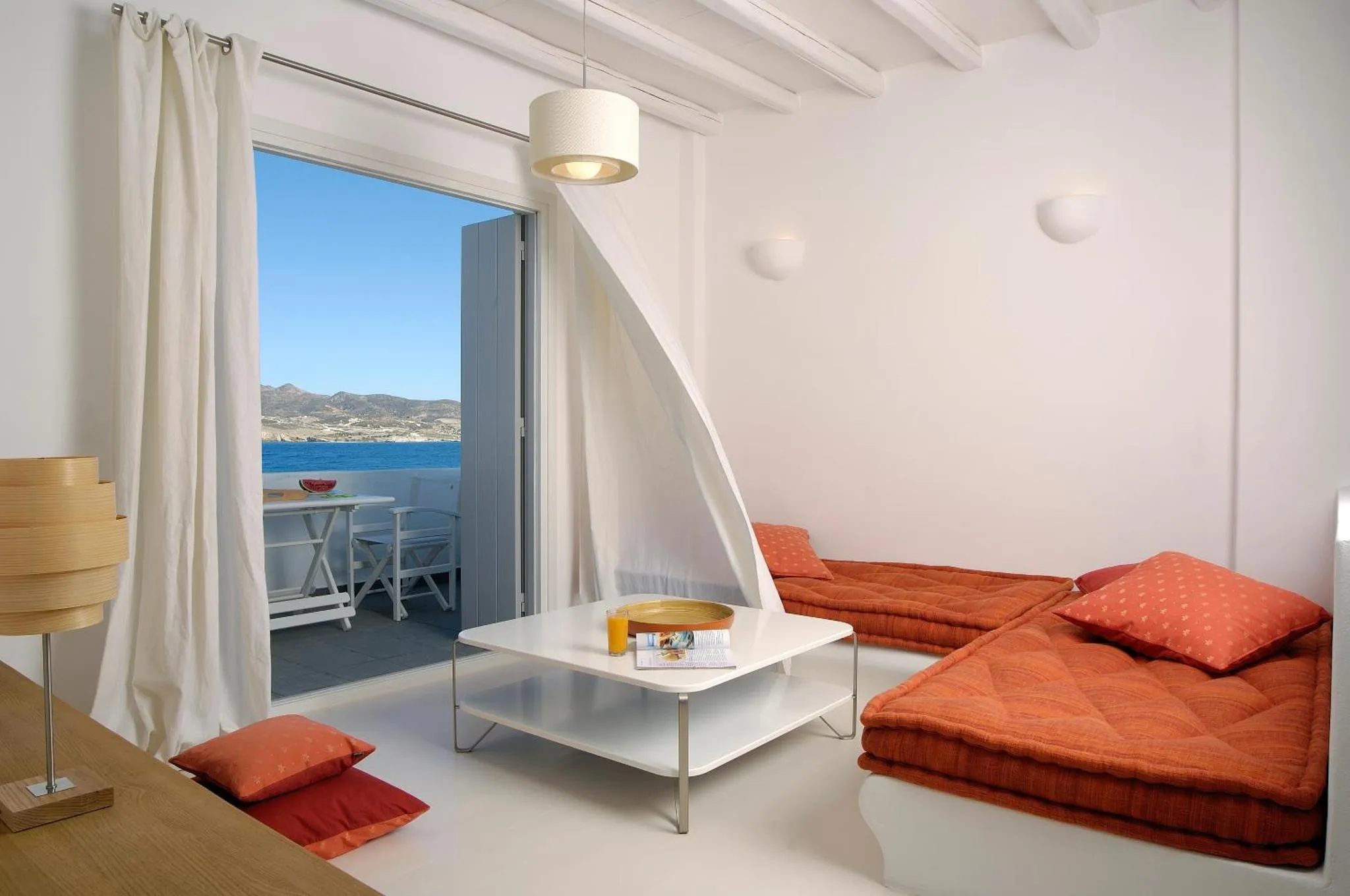 Espace de vie lumineux avec canapé et vue sur la mer.