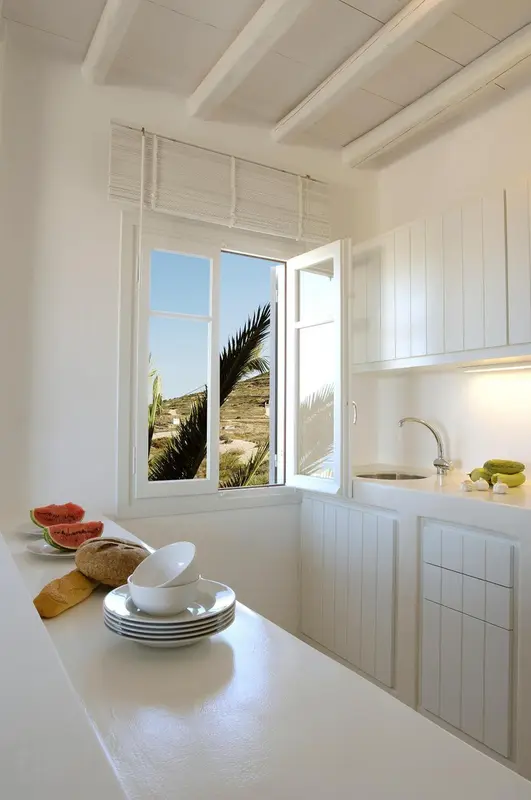 Une cuisine lumineuse donne sur une vue de palmiers et de dunes.