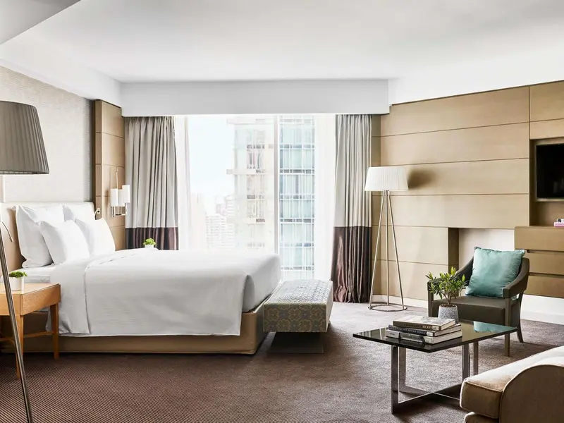 Une chambre lumineuse avec un grand lit et un coin salon.