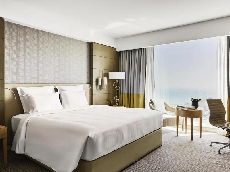 Une chambre lumineuse avec un grand lit et une vue sur la mer.
