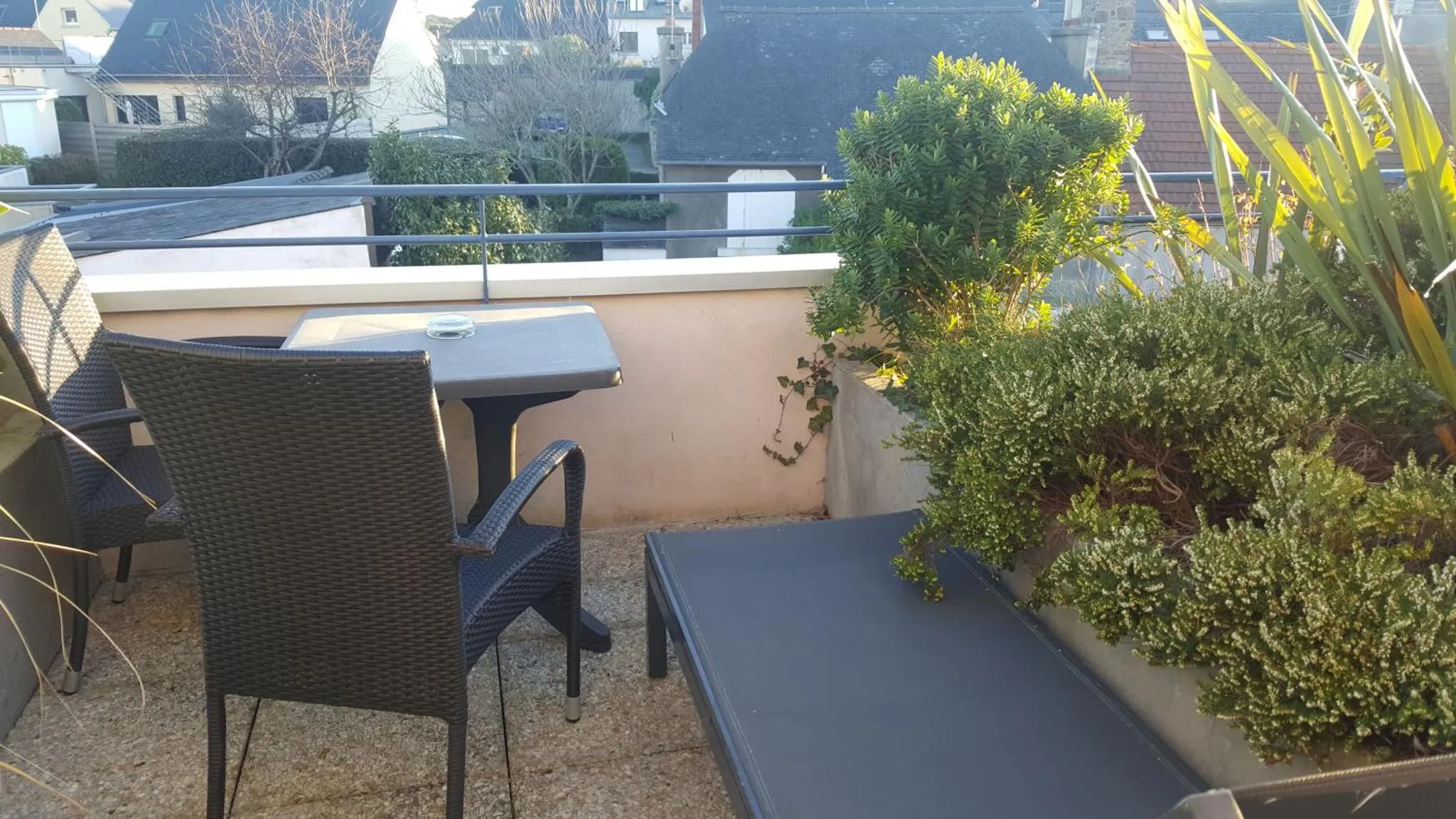 Terrasse aménagée avec mobilier de jardin et plantes.