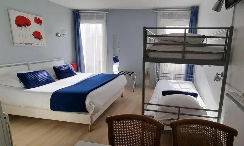Une chambre avec un lit double et un lit superposé.