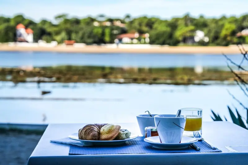 Une table est dressée avec un petit-déjeuner face à la mer.