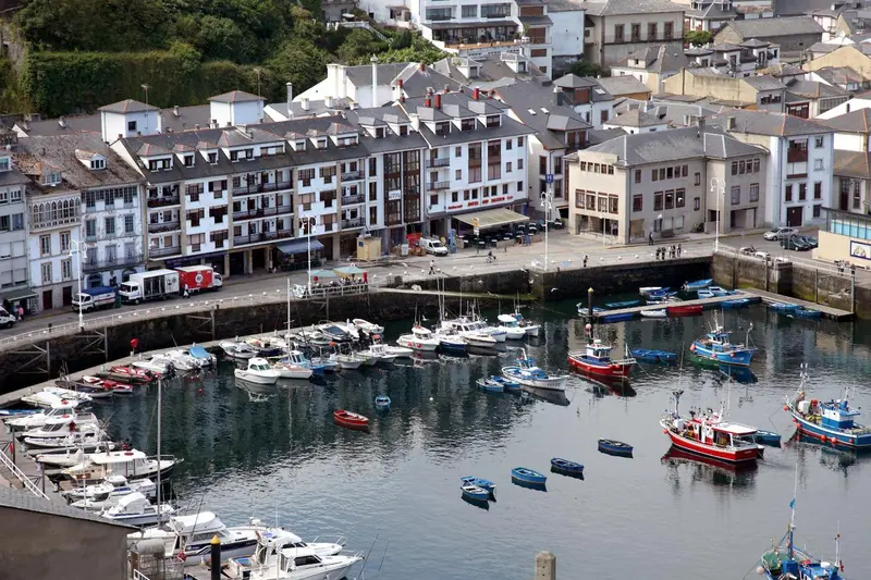 Vue aérienne d'un port de plaisance avec des bâtiments aux façades blanches et colorées.