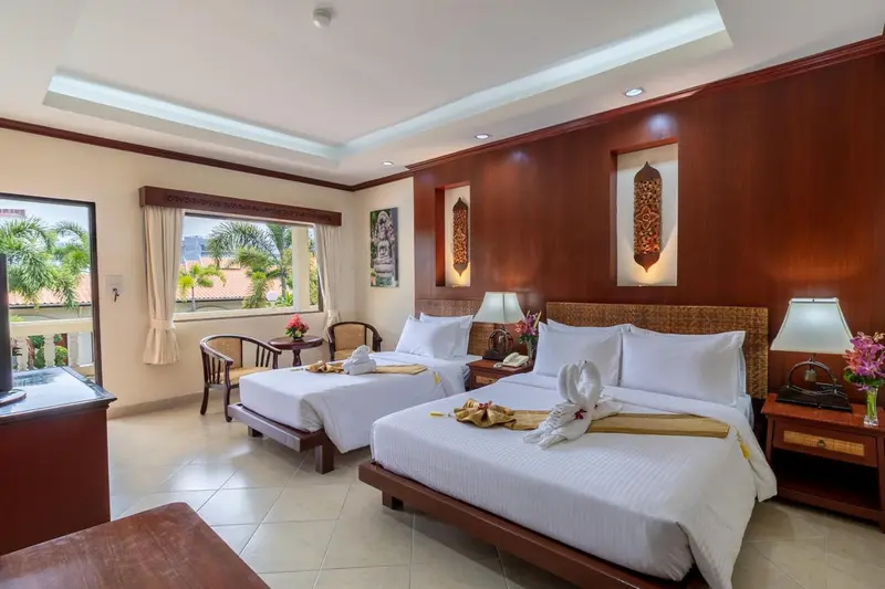 Chambre lumineuse avec deux lits simples et une décoration florale.