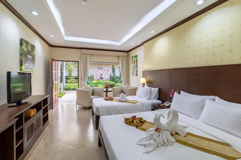 Chambre lumineuse avec deux lits et accès à une terrasse.