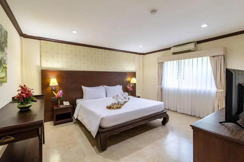 Une chambre d'hôtel lumineuse avec un grand lit et une décoration florale.