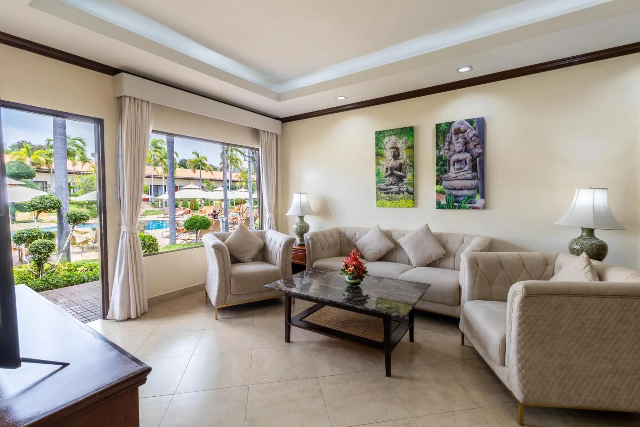 Espace de détente intérieur avec canapés et vue sur une piscine.