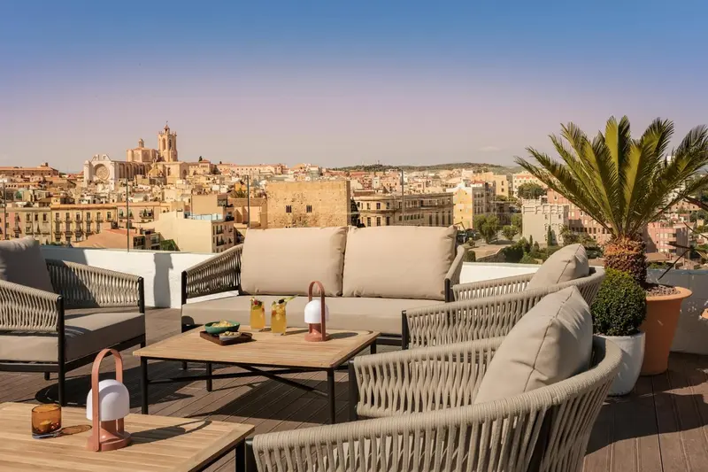Espace de détente extérieur avec mobilier confortable et vue sur la ville.
