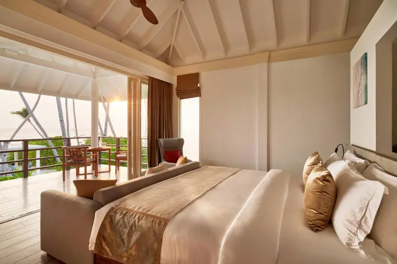 Une chambre lumineuse s'ouvre sur une terrasse avec vue sur la mer.