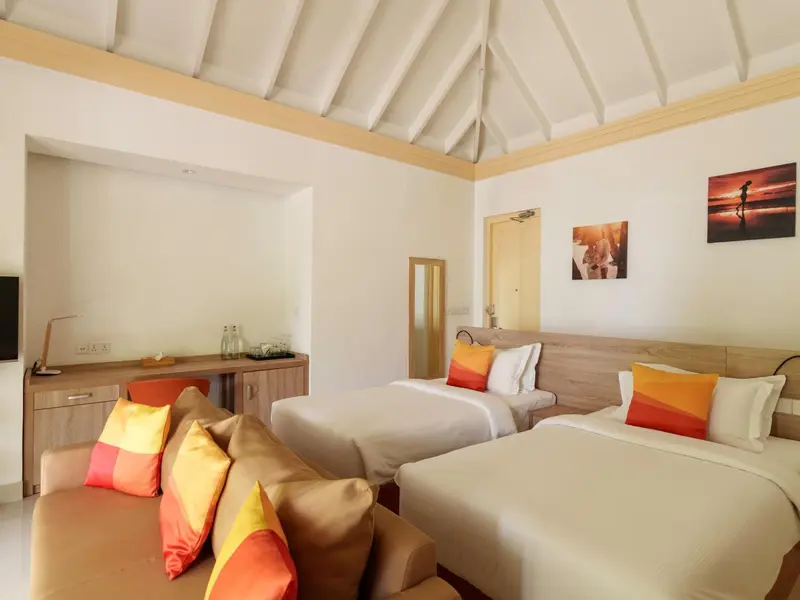 Une chambre lumineuse avec deux lits simples et un canapé.