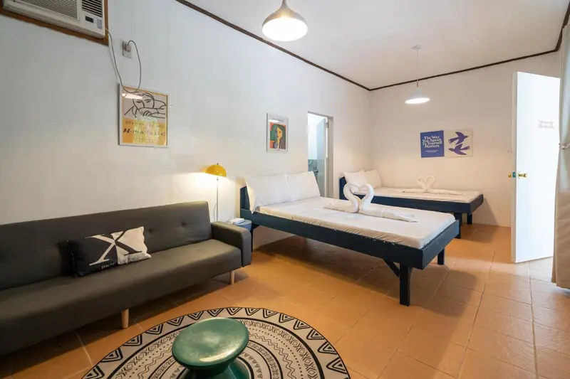 Espace de vie intérieur avec canapé, lit et décoration murale.