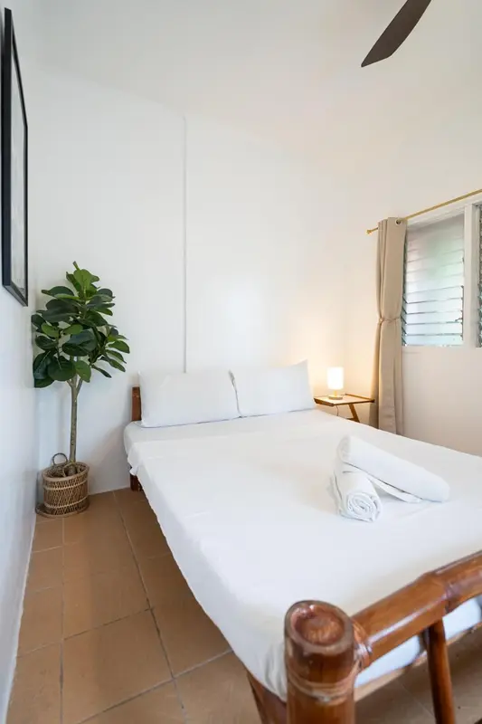 Une chambre lumineuse avec un lit simple et une décoration minimaliste.