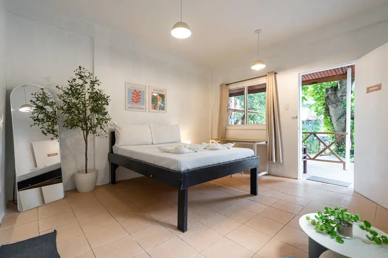 Une chambre lumineuse avec un lit simple et un accès à une terrasse.
