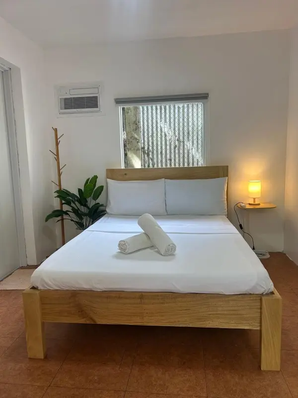 Une chambre lumineuse avec un grand lit recouvert de draps blancs.