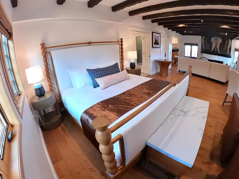 Une chambre lumineuse avec un grand lit et un coin salon.