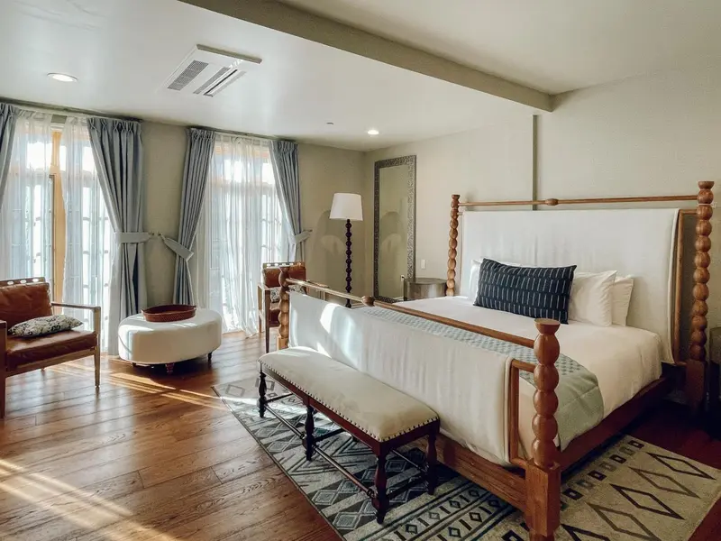 Une chambre spacieuse avec un grand lit à baldaquin et un fauteuil.
