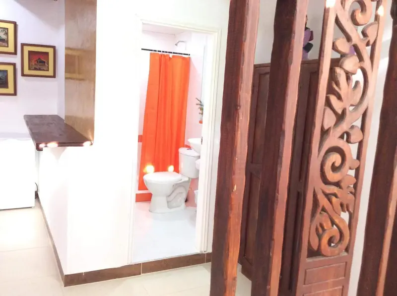 Une salle de bain lumineuse avec une douche orange et des toilettes.