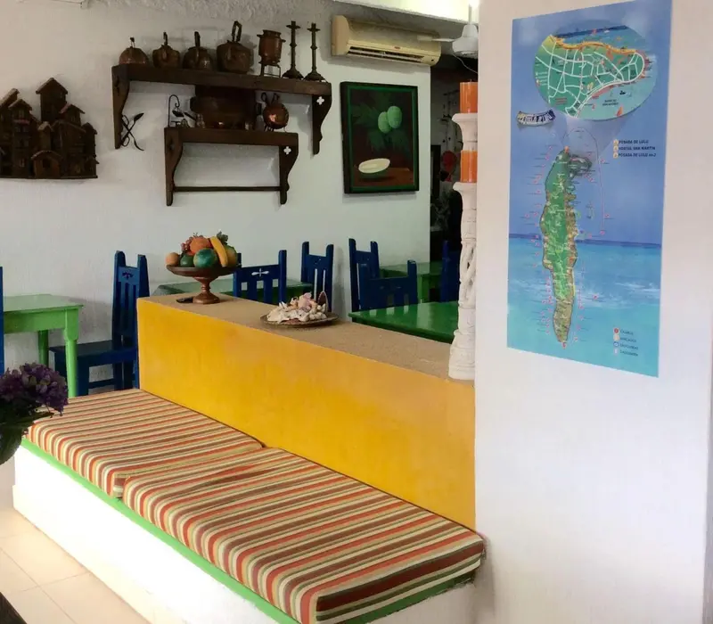 Espace de repas coloré avec banquettes et table basse.