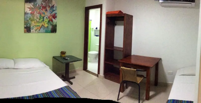 Une chambre lumineuse avec un lit et un bureau en bois.