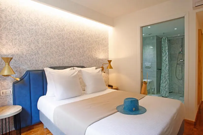 Une chambre lumineuse avec un grand lit et une salle de bain attenante.