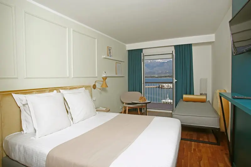 Chambre lumineuse avec un lit double et une vue sur la mer.