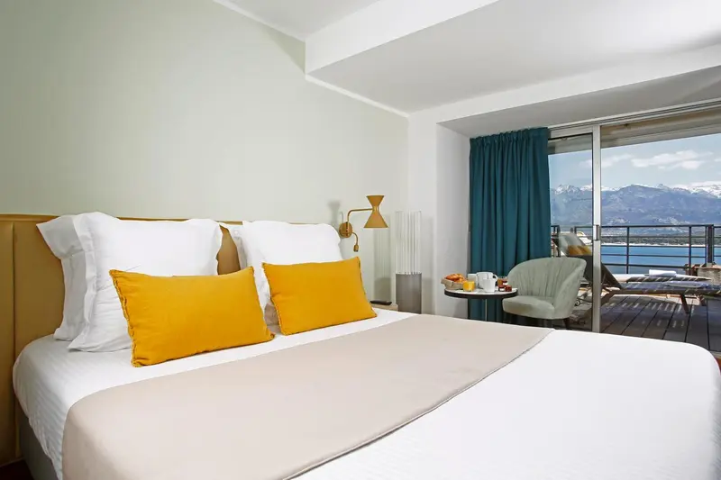 Une chambre lumineuse avec un grand lit et une vue sur la mer.