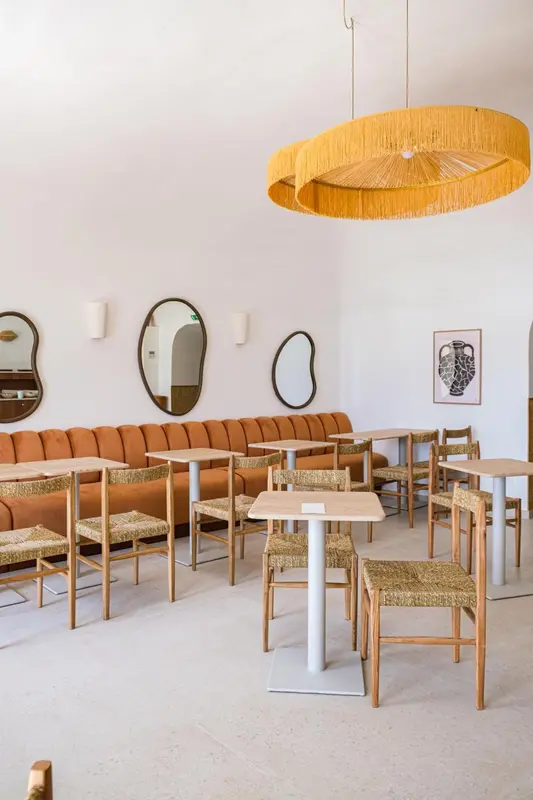 Une salle à manger lumineuse avec des tables et des chaises en bois.