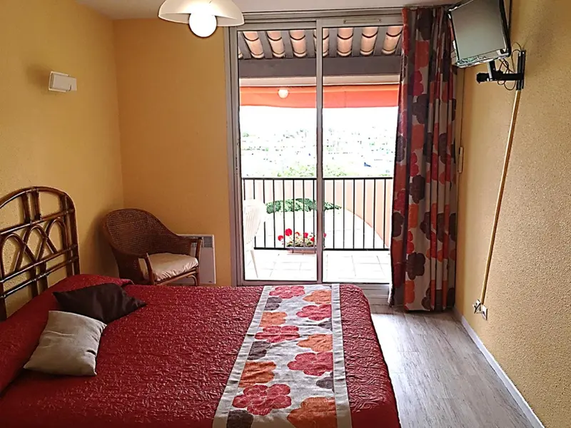 Une chambre avec un lit et un accès à un balcon.