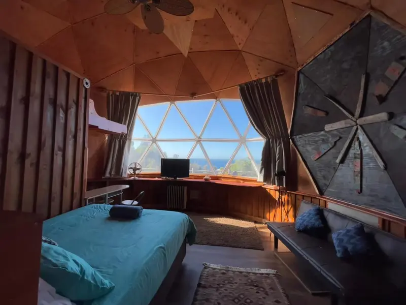 Une chambre lumineuse avec un lit fait et un espace détente.