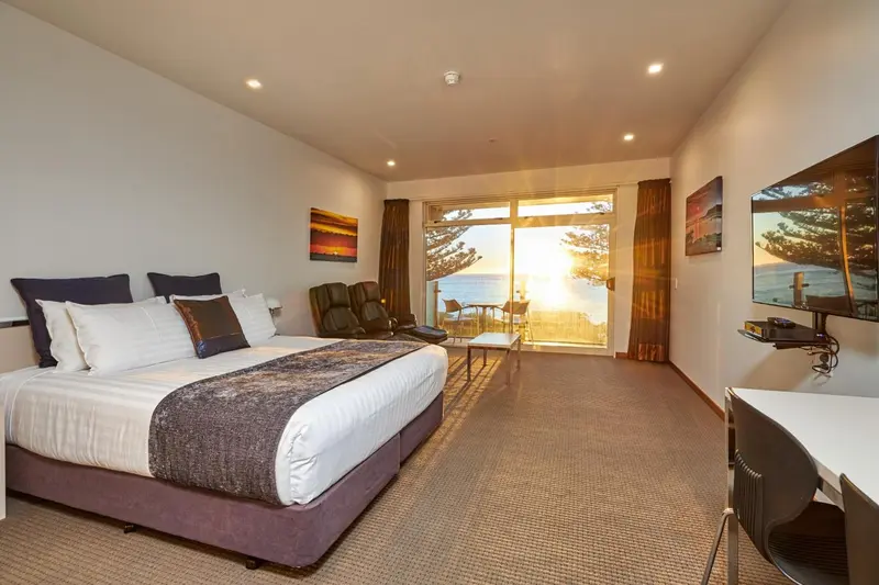 Une chambre lumineuse avec un grand lit et une vue sur la mer.