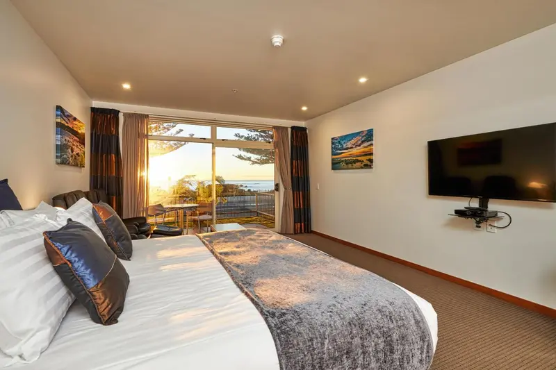 Une chambre lumineuse avec un grand lit et une vue sur la mer.