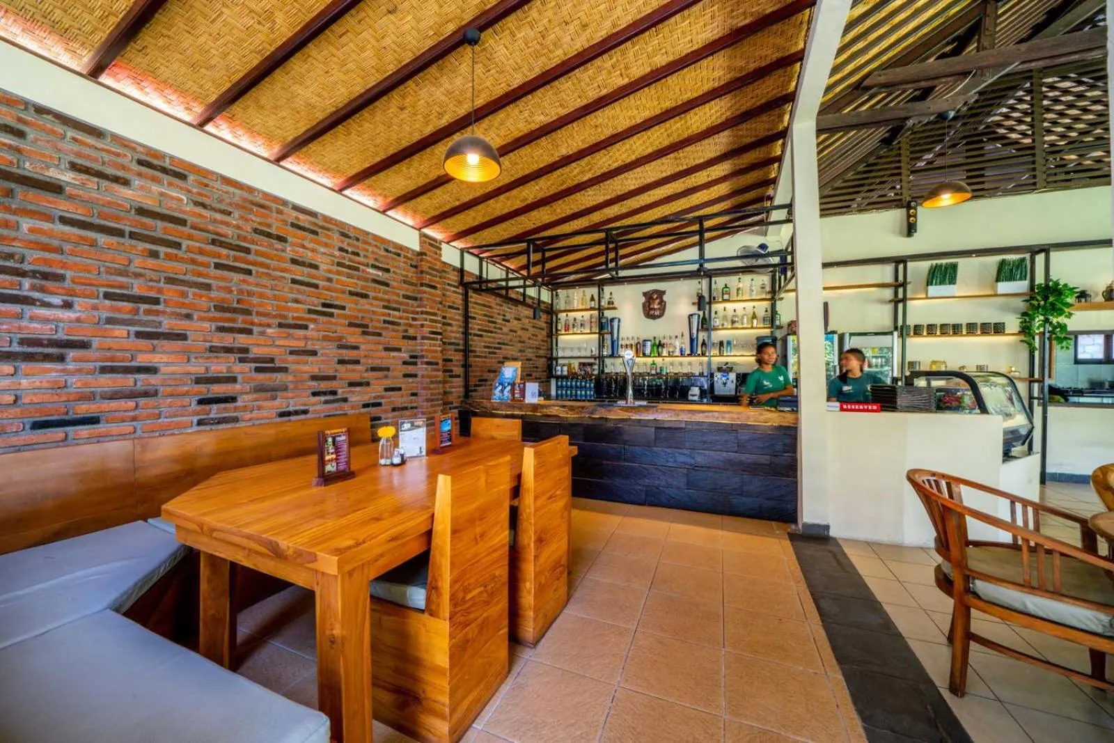 Une salle de restaurant avec un comptoir de bar et des tables en bois.