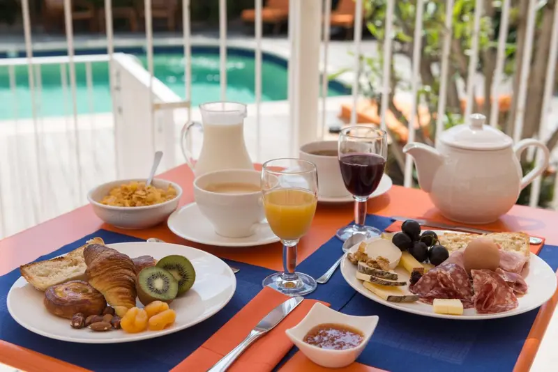 Une table colorée est dressée pour un copieux petit-déjeuner.
