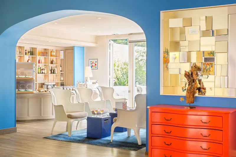 Un espace de détente lumineux avec des fauteuils et un bar en fond.