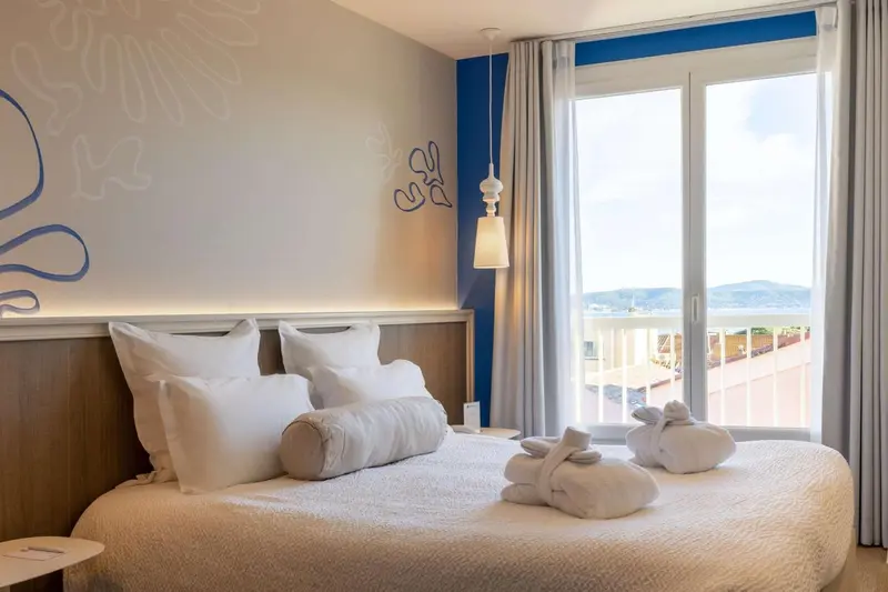 Une chambre lumineuse avec un grand lit et vue sur la mer.